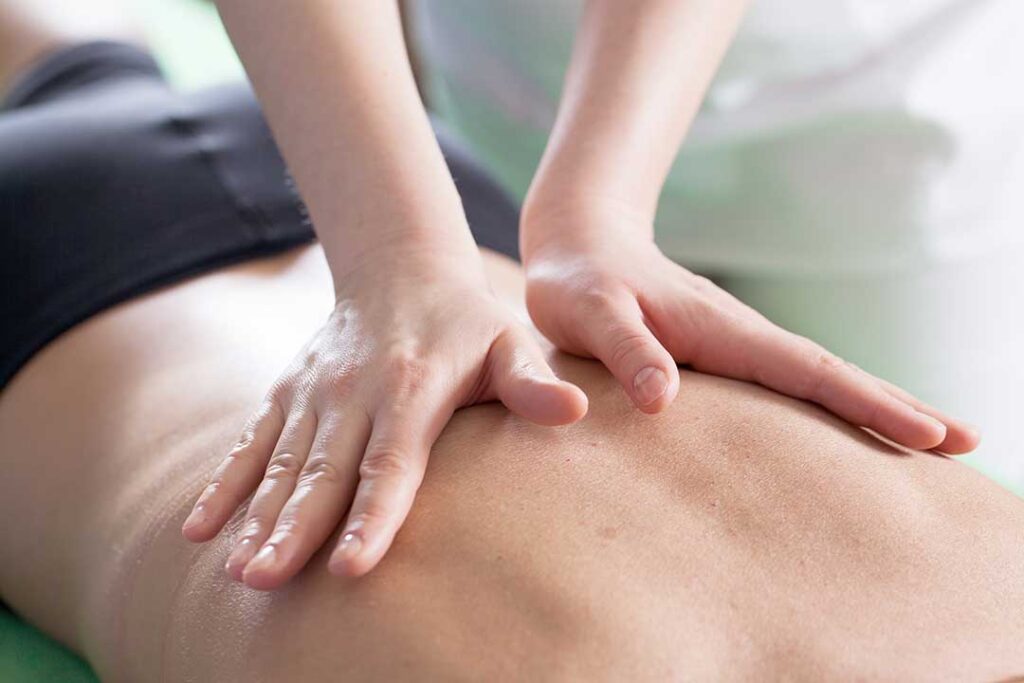 Person gently turning their neck while seated at home, with a hand resting on the shoulder